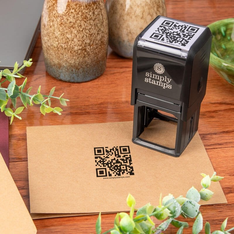 Self-inking QR code stamp from Simply Stamps shown creating a clean impression on a brown paper envelope