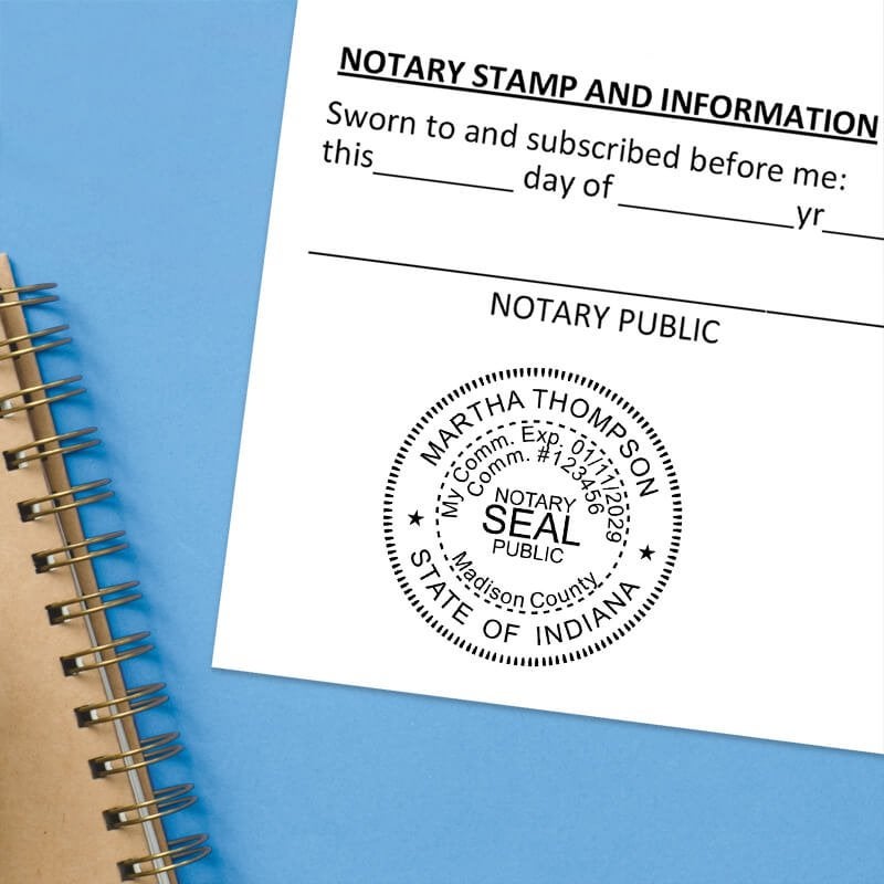 Indiana notary seal impression on jurat form with spiral notebook on blue background.