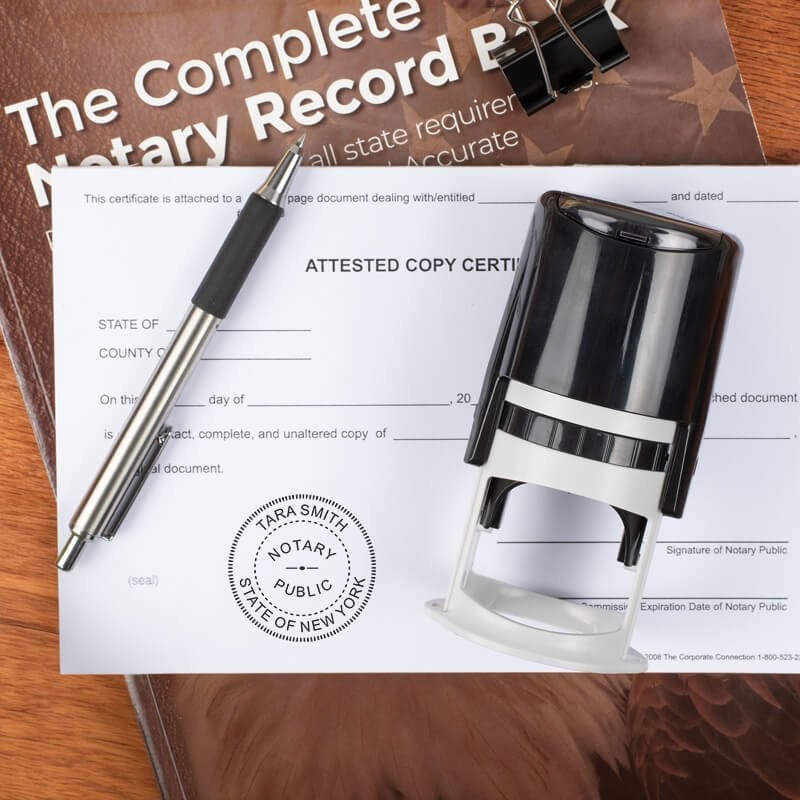 New York notary stamp on form with pen and record book on wood surface.