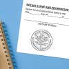 Notary public stamp impression on signed document above notebook