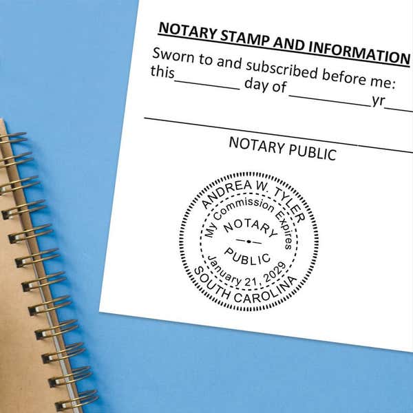 Notary public stamp impression on signed document above notebook