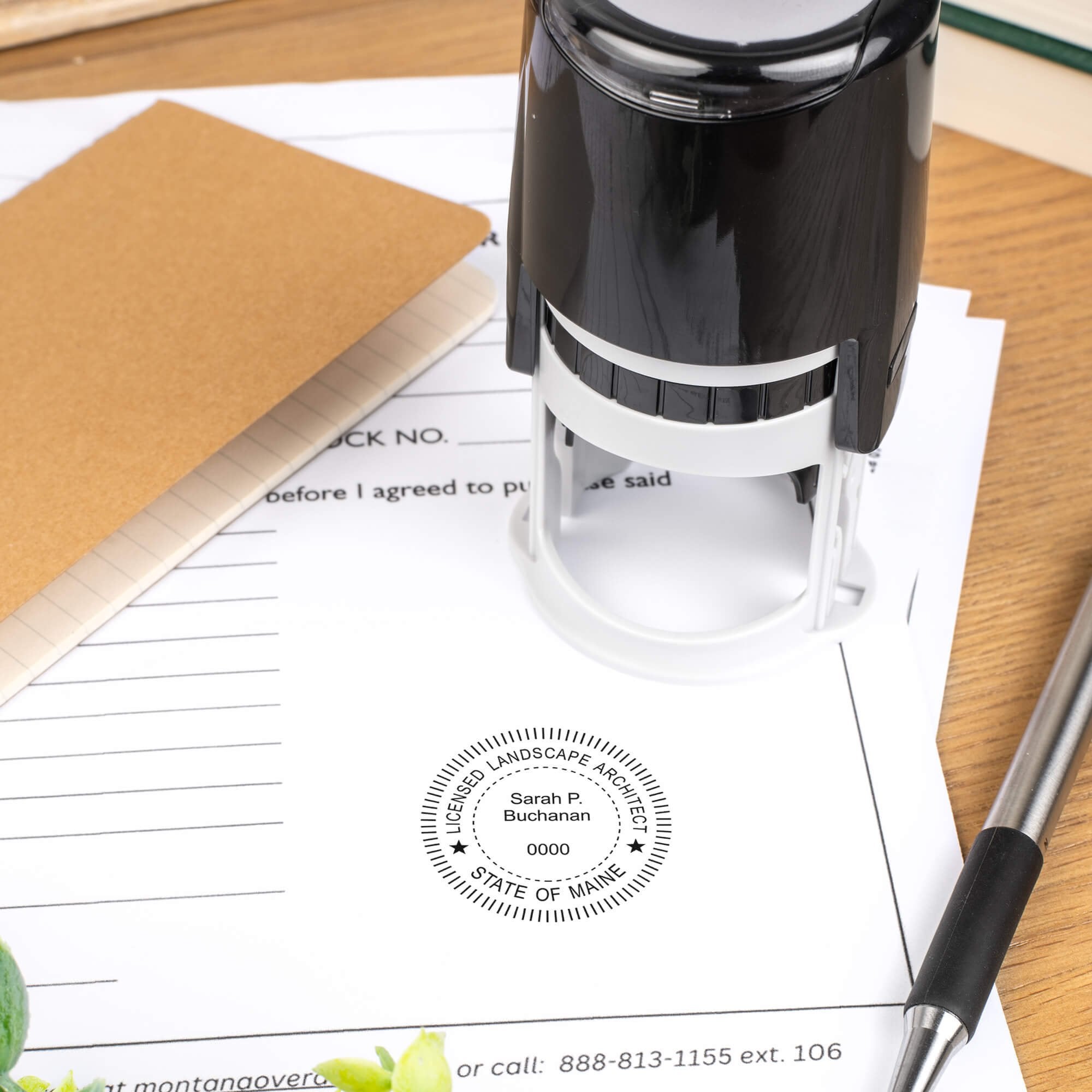 A self-inking stamp placed next to the State of Maine Landscape Architect Embosser Seal at the bottom of a document