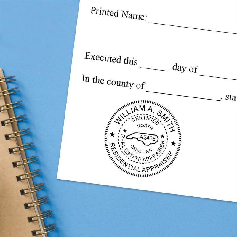 North Carolina notary stamp impression on white paper on a blue notebook. 