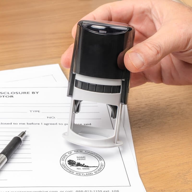 The State of New Hampshire Wetland Scientist Seal being used on a document with a self-inking stamp