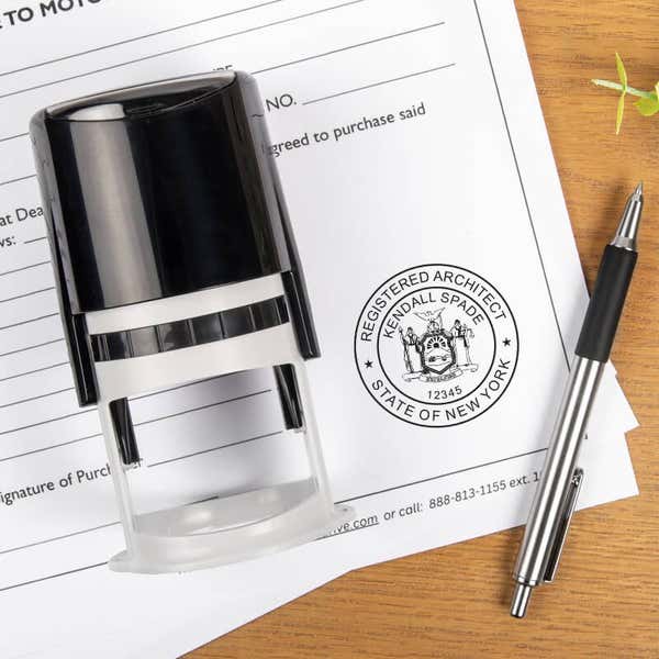 State of New York Architect stamp on a document next to the stamp body and a pen