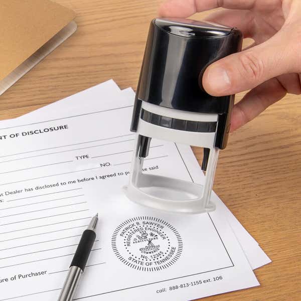 The State of Tennessee Engineer Seal being used on a document next to a pen