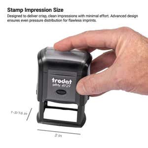 Hand holding Trodat Printy 4929 stamp over paper, showing impression size of 1-3/16 inches by 2 inches