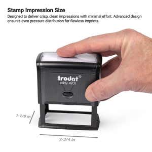 A hand pressing down on a Trodat Printy 4931 self-inking stamp. Impression size is labeled as 1-1/8" x 2-3/4"