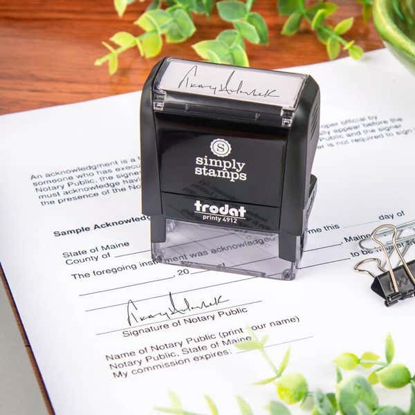 Custom rubber stamp with signature on paper. 