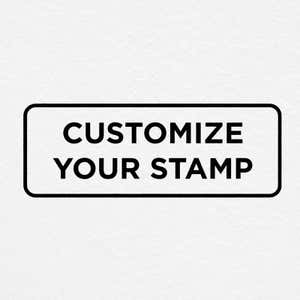 Stamp impression on paper reading 'Customize Your Stamp' in bold lettering, showcasing a sample design layout for personalized stamps.