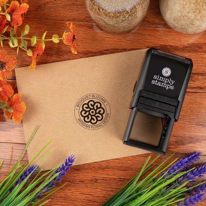 Custom self-inking stamp next to a kraft envelope featuring a round logo stamp with text surrounding