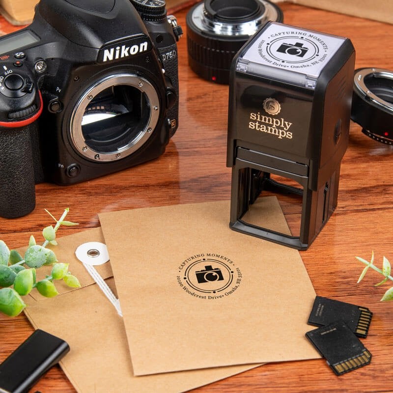 Custom round stamp being used with a camera logo and business information printed on an envelope