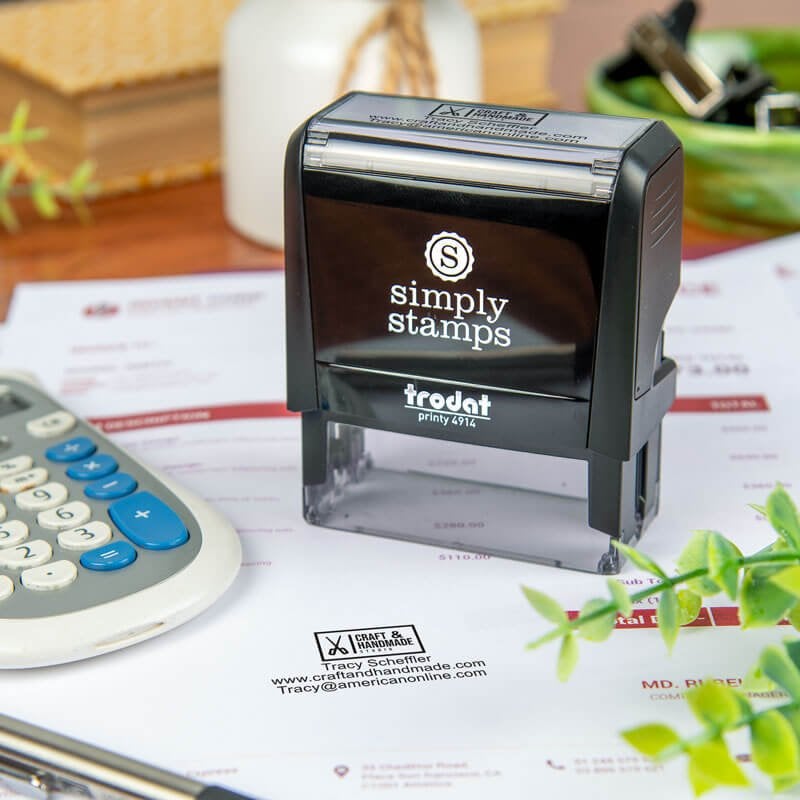 Simply Stamps self-inking stamp resting on a document that has been stamped with a business logo and informational text
