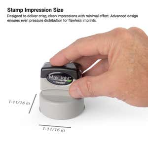 Hand pressing down on a MaxLight by Trodat pre-inked stamp, showing impression size dimensions of 1-11/16" x 1-11/16"