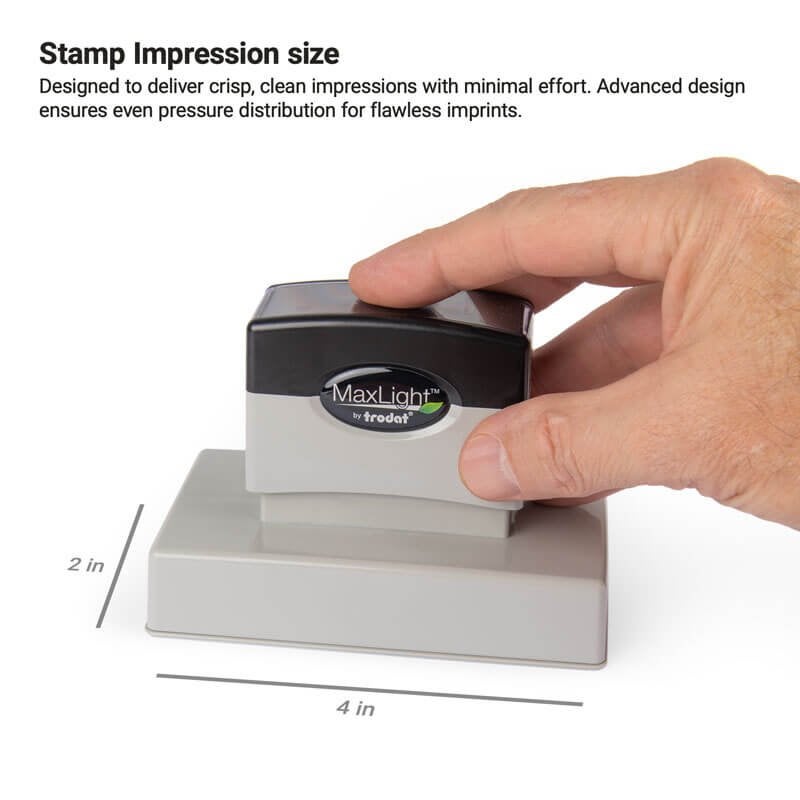 Hand pressing down on a MaxLight pre-inked stamp to demonstrate a 2" x 4" impression size