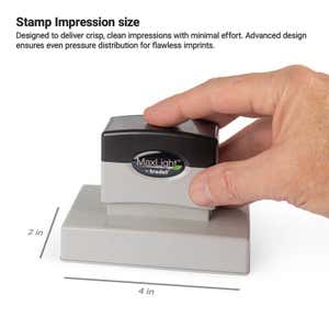Hand pressing down on a MaxLight pre-inked stamp to demonstrate a 2" x 4" impression size