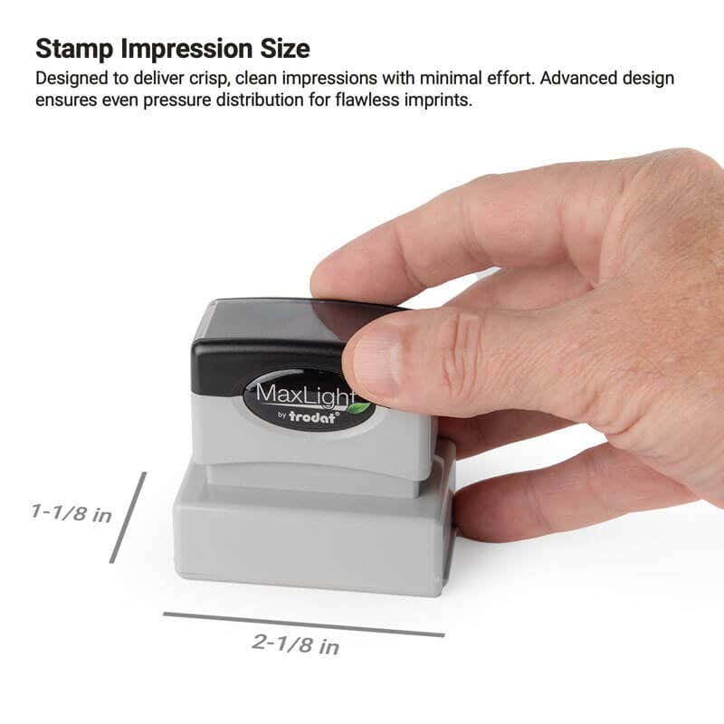 Hand pressing a MaxLight stamp with impression size labeled as 2-1/16" x 13/16"