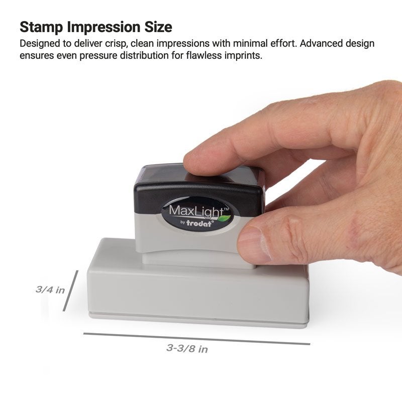 A hand pressing a MaxLight stamp with an impression size of  3/4" x 3-3/8"