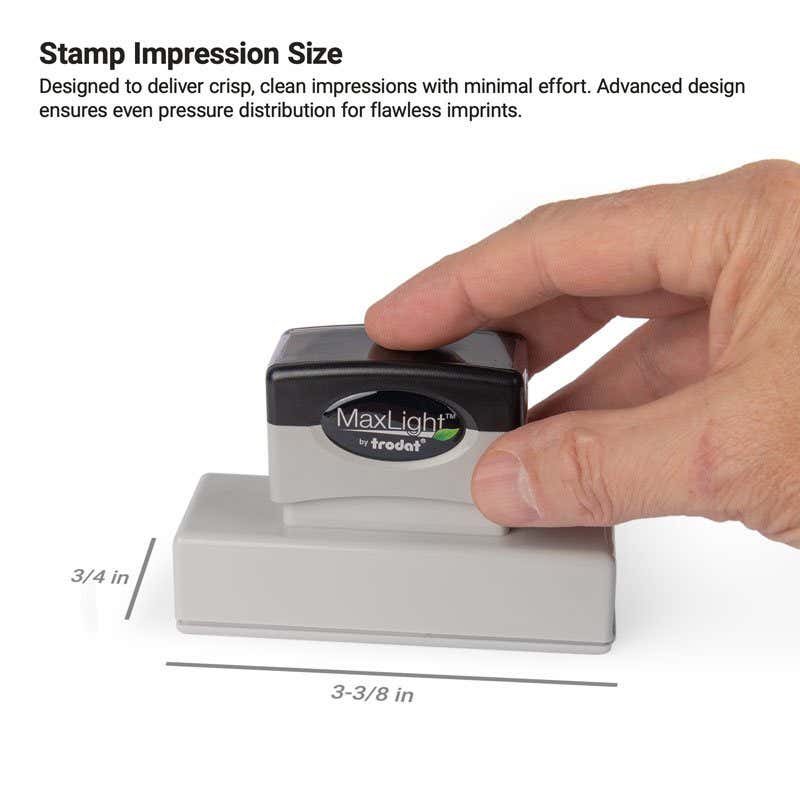 A hand pressing a MaxLight stamp with an impression size of  3/4" x 3-3/8"