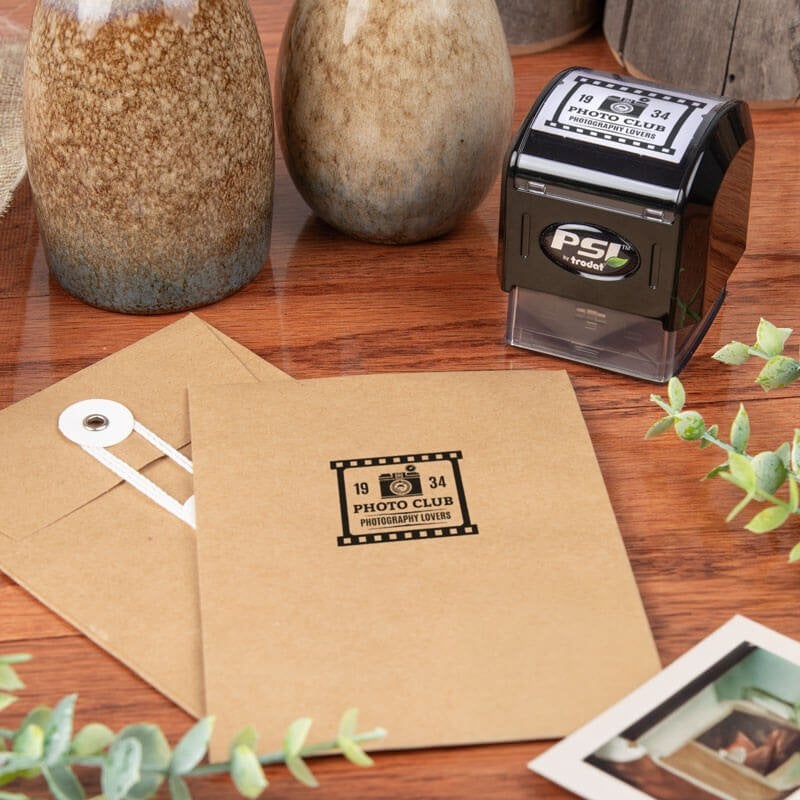 Simply Stamps self-inking stamp shown with a custom logo that has been applied to envelopes