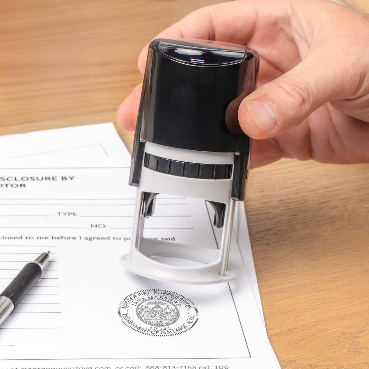 The State of New York Master Fire Suppression Seal being used on a document with a self-inking stamp