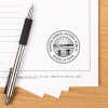 Ohio notary stamp impression on paper with pen on wood desk.