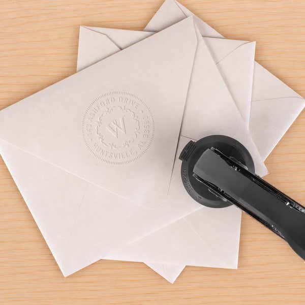 Seal Logo Embosser in use, with a stamped logo impression on packaging