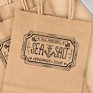 Large 3" x 4" Custom Pre-Inked Rectangular Logo Stamp in use, with a stamped logo impression on packaging