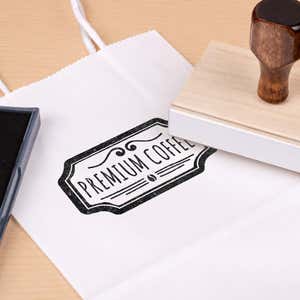 3 inch Custom Logo Stamp resting beside a freshly stamped custom logo impression