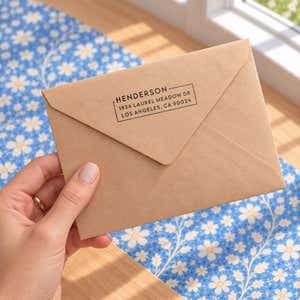 Hand holding an envelope stamped with the Urban Custom Address Stamp