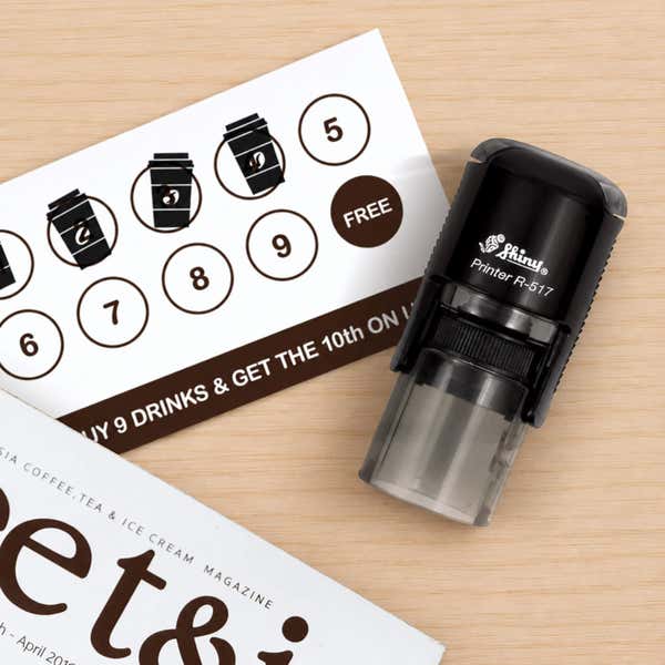 Mini Round Self-Inking Logo Stamp in use, with a stamped logo impression on packaging