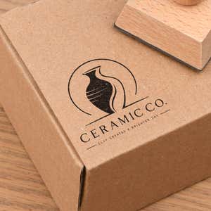 Small Wood Handle Custom Logo Stamp in use, with a stamped logo impression on packaging