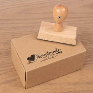 Custom Medium Rectangle Logo Hand Stamp resting beside a freshly stamped custom logo impression