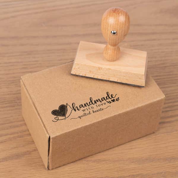 Custom Medium Rectangle Logo Hand Stamp resting beside a freshly stamped custom logo impression