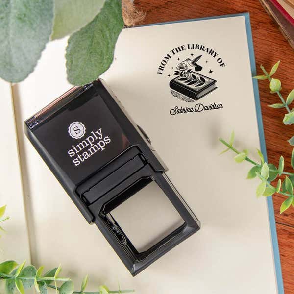 Library book stamp with self-inking stamp body on a book page