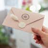 Joy Peace Love Round Address Stamp on back of envelope in hand
