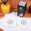 Joy Peace Love Round Address Stamp design impression on two envelopes next to self inking stamp body