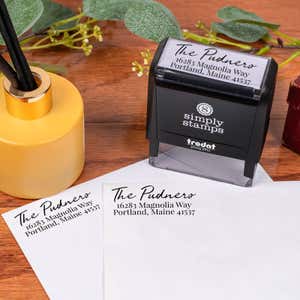 Relaxed Script Custom Address Stamp design impression on two envelopes next to self inking stamp body