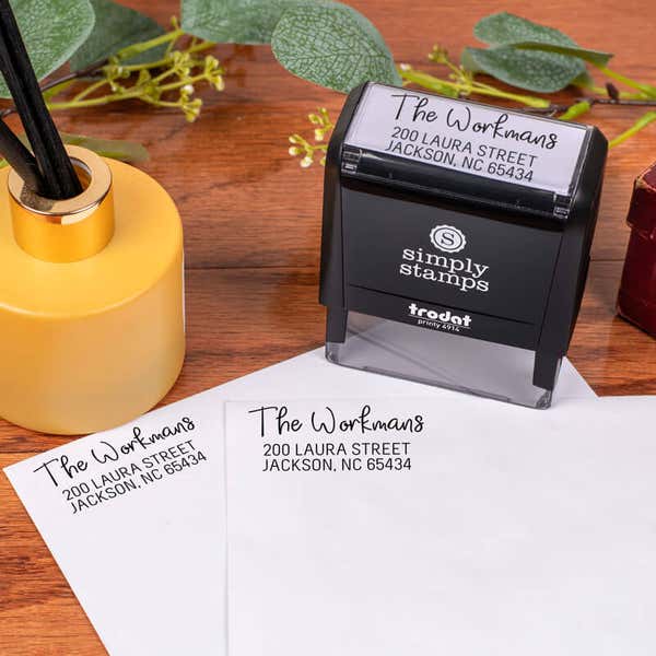 Workman Address Stamp design impression on two envelopes next to self inking stamp body