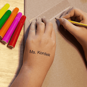 View of the impression of the Teacher Classroom Stamp on a child's hand