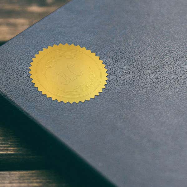 Library book embosser impression on gold sticker on blue book