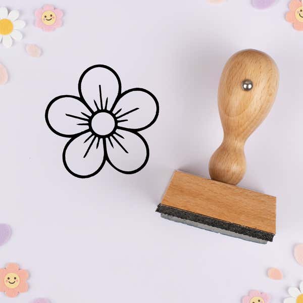 Five-petal blossom stamped in black on lavender cardstock with smiling daisy confetti