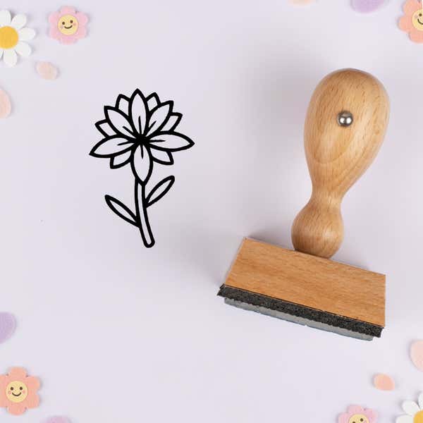 Starburst petal flower stamped in black on lavender cardstock with smiling daisy confetti