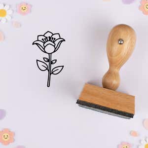 Flared petal flower stamped in black on lavender cardstock with smiling daisy confetti
