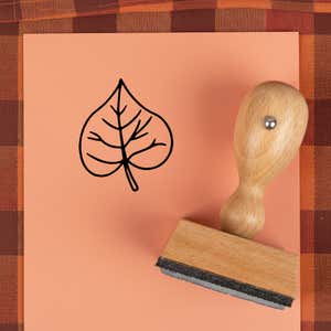 Veined heart leaf stamped in black on peach cardstock on a plaid autumn cloth
