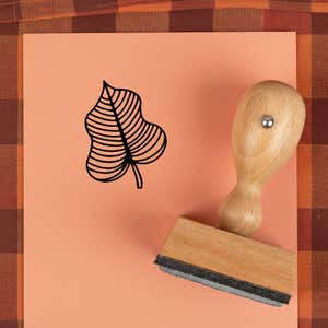 Striped vein leaf stamped in black on peach cardstock on a plaid autumn cloth