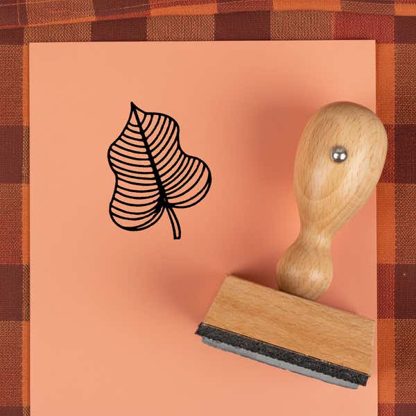 Striped vein leaf stamped in black on peach cardstock on a plaid autumn cloth