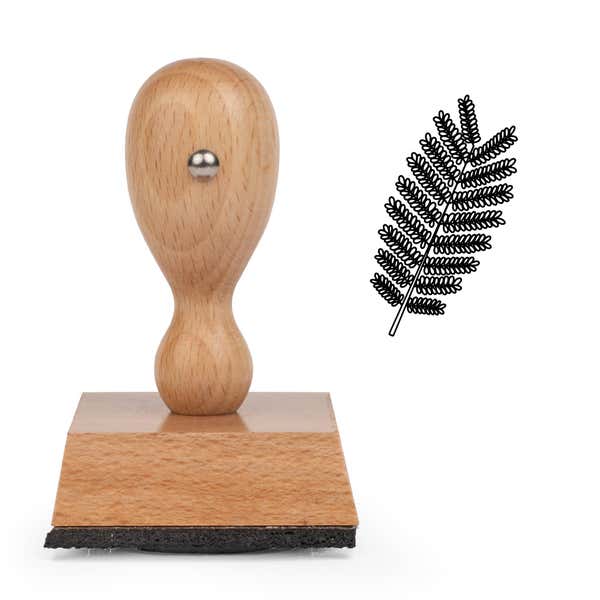 Fern Frond Craft Stamp standing upright beside its black stamped fern frond image