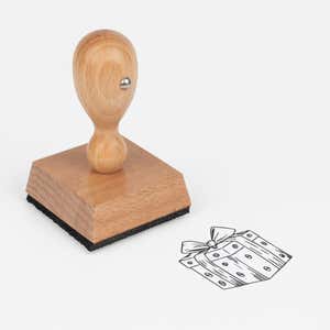 Wrapped Gift Box Craft Stamp at an angle, showing the wooden handle, square block and stamped wrapped gift box