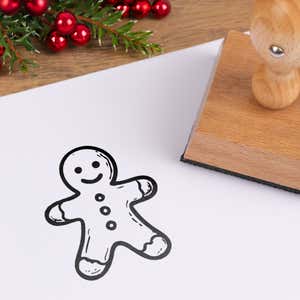 Classic gingerbread stamped in black on white cardstock styled with red berries and pine greenery